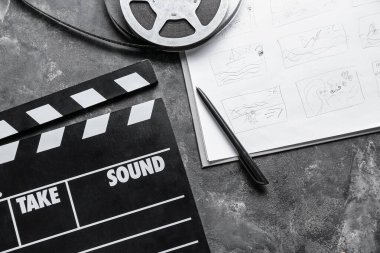 Karanlık arka planda film makarası ve film makarası olan hikaye tahtası