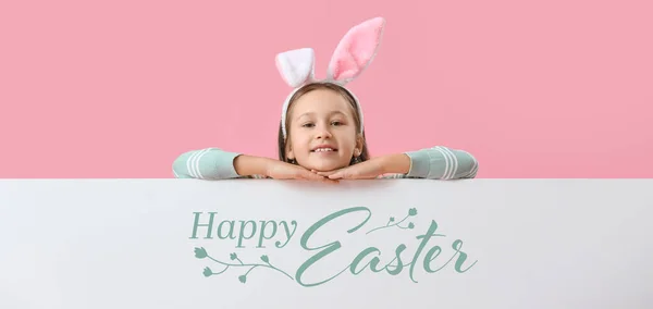 Little girl and poster with text HAPPY EASTER on pink background