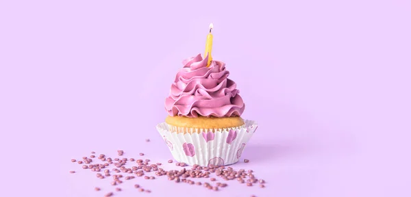 おいしい誕生日カップケーキライラックの背景に燃えるキャンドル — ストック写真