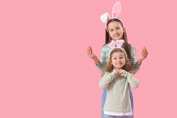 Pembe Arka Planda Paskalya Yumurtaları Olan Tavşan Kulaklı Küçük Kızlar — Stok fotoğraf