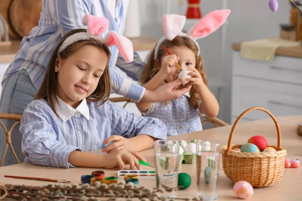 小女孩和妈妈一起在厨房的桌子上画复活节彩蛋 — 图库照片