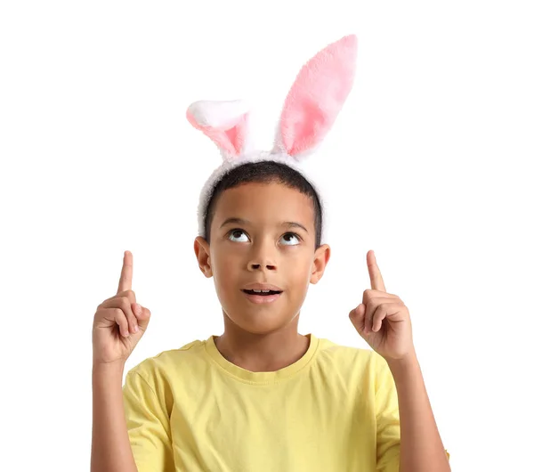 白い背景に何かを指しているウサギの耳の中に小さなアフリカ系アメリカ人の少年 イースターのお祝い — ストック写真
