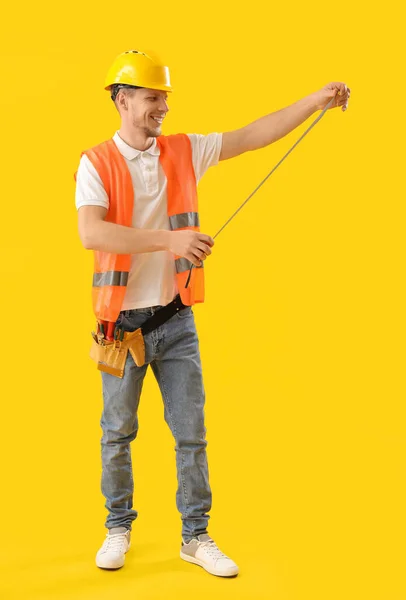 Trabalhador Masculino Com Régua Fita Fundo Amarelo — Fotografia de Stock