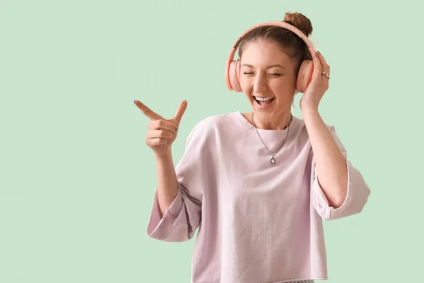 Young Woman Headphones Pointing Something Green Background — Stock Photo, Image