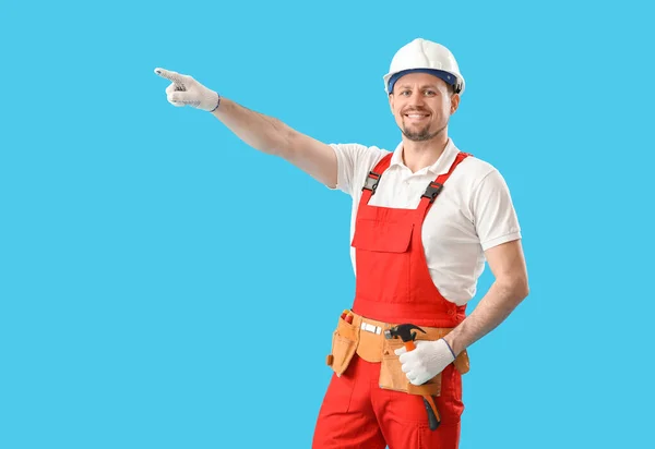 Homem Carpinteiro Com Martelo Apontando Para Algo Fundo Azul — Fotografia de Stock