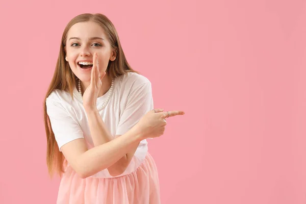 Glückliche Junge Frau Shirt Zeigt Auf Etwas Auf Rosa Hintergrund — Stockfoto