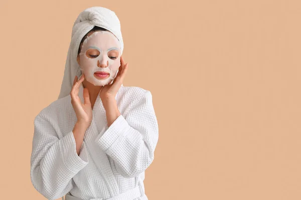 Young Woman Bathrobe Sheet Mask Beige Background — Stock Photo, Image