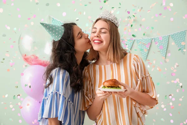 快乐的年轻女性 带着汉堡包在绿色背景下庆祝生日 — 图库照片