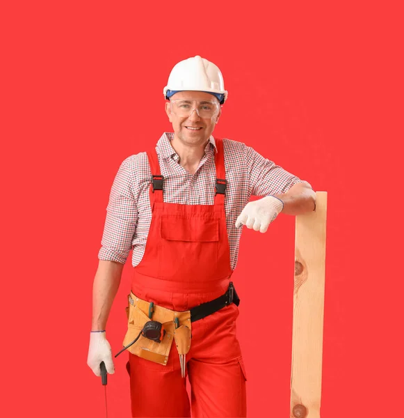 Mature Carpenter Hacksaw Wooden Plank Red Background — Stock Photo, Image