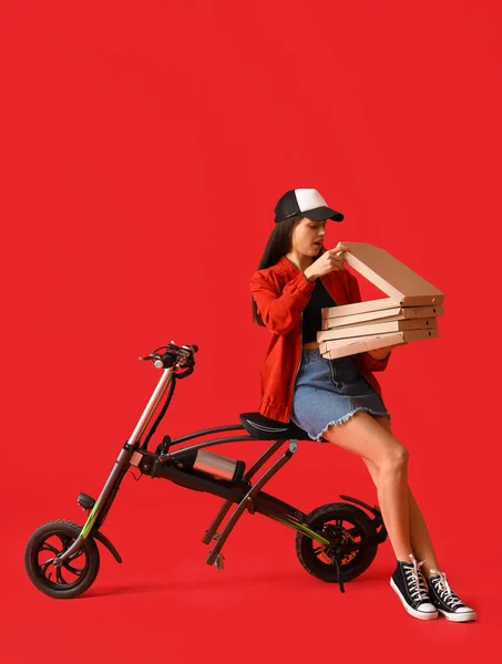 Νεαρή Γυναίκα Κουτιά Νόστιμη Πίτσα Και Ηλεκτρικό Ποδήλατο Κόκκινο Φόντο — Φωτογραφία Αρχείου