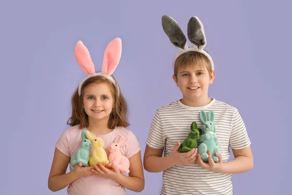 ライラックの背景にイースターウサギとウサギの耳の小さな子供たち — ストック写真