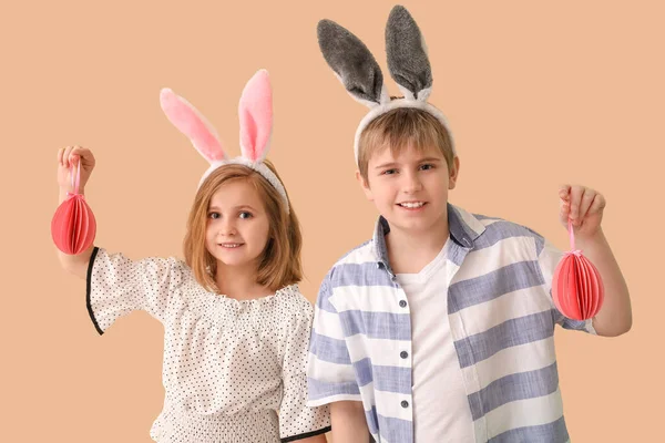 小さな子供でウサギの耳で紙イースターエッグベージュの背景 — ストック写真