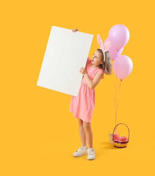 小さな女の子でウサギの耳ともに空のポスターと風船で黄色の背景 — ストック写真