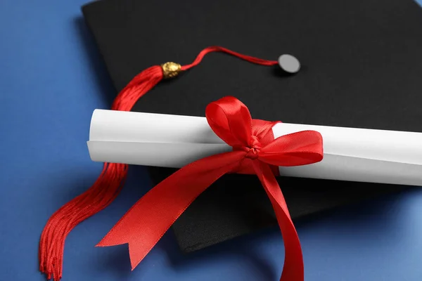 Kırmızı Kurdeleli Diploma Mavi Arka Planda Mezuniyet Şapkası — Stok fotoğraf