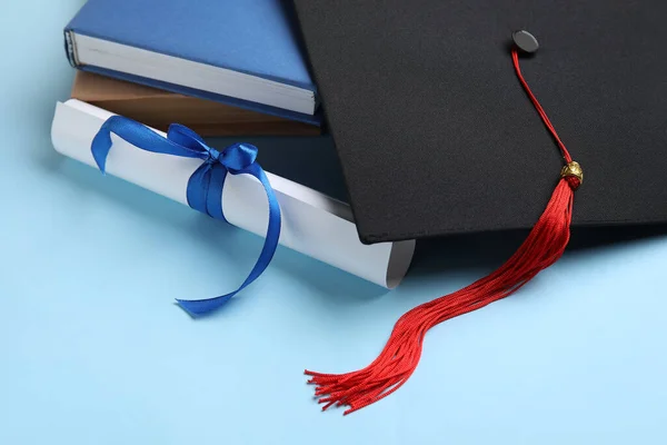 Δίπλωμα Κορδέλα Καπέλο Αποφοίτησης Και Βιβλία Μπλε Φόντο — Φωτογραφία Αρχείου