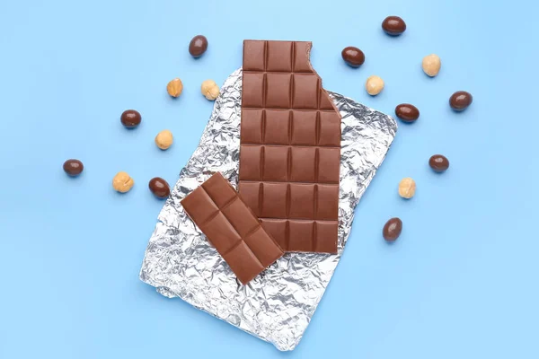 Hoja Con Sabroso Chocolate Caramelos Avellanas Sobre Fondo Color — Foto de Stock