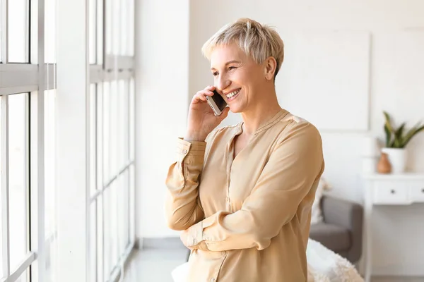 Mature Woman Talking Mobile Phone Home — Stock Photo, Image