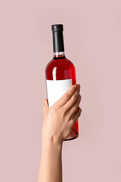 Weibliche Hand Hält Flasche Rotwein Auf Rosa Hintergrund — Stockfoto