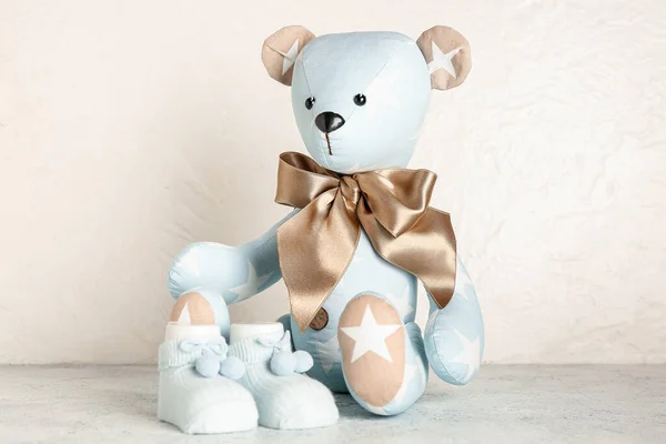 Urso Brinquedo Com Meias Bebê Mesa Perto Parede Leve — Fotografia de Stock
