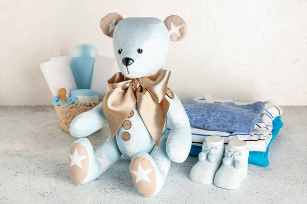Speelgoedbeer Met Babykleertjes Accessoires Tafel Bij Lichte Wand — Stockfoto