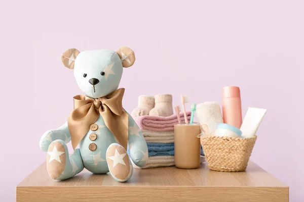 Speelgoedbeer Met Babykleding Accessoires Tafel Buurt Van Lila Muur — Stockfoto