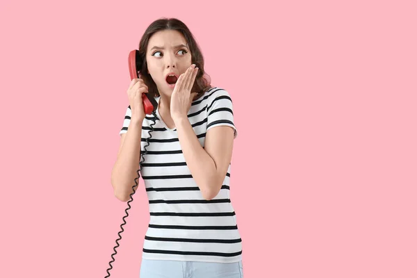 Mujer Joven Conmocionada Con Receptor Teléfono Sobre Fondo Rosa — Foto de Stock