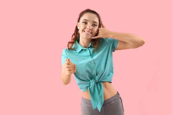 Young Woman Showing Call Gesture Pointing Viewer Pink Background — Stock Photo, Image
