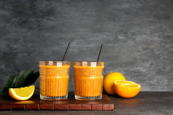 stock image Glasses of healthy orange smoothie on dark background