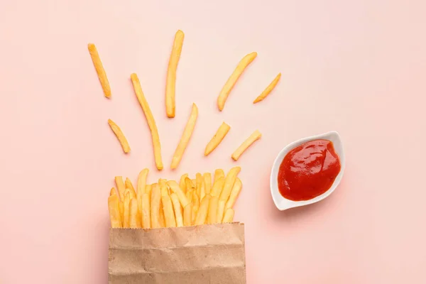 粉红背景的法式薯条和番茄酱 — 图库照片