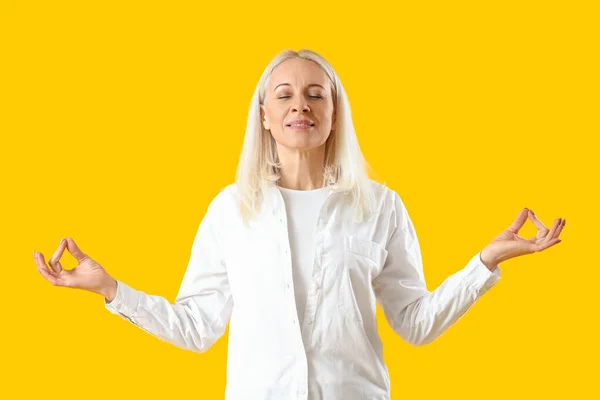 Volwassen Vrouw Mediteren Gele Achtergrond — Stockfoto