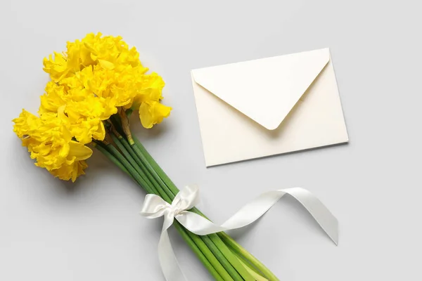 Mooie Narcissen Bloemen Met Lint Envelop Lichte Achtergrond — Stockfoto