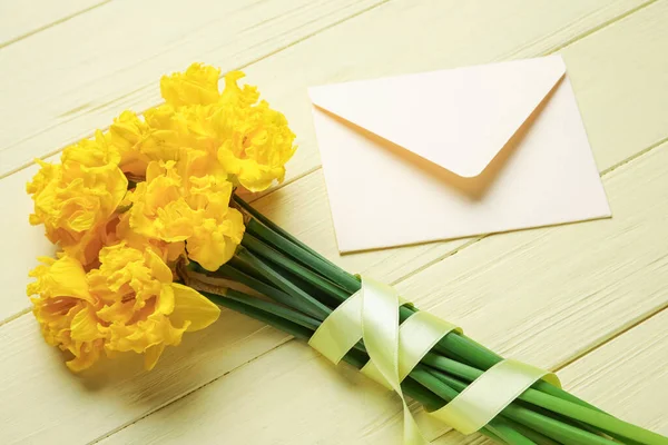 Vackra Narcissus Blommor Med Gult Band Och Kuvert Ljus Trä — Stockfoto