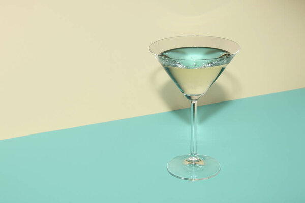 Glass of martini on color background