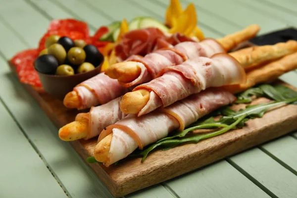 Styrelse Välsmakande Italienska Grissini Med Bacon Grön Trä Bakgrund Närbild — Stockfoto