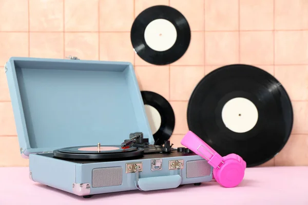レコードプレーヤービニールディスクとヘッドフォンベージュタイル壁の近くのテーブルの上に — ストック写真
