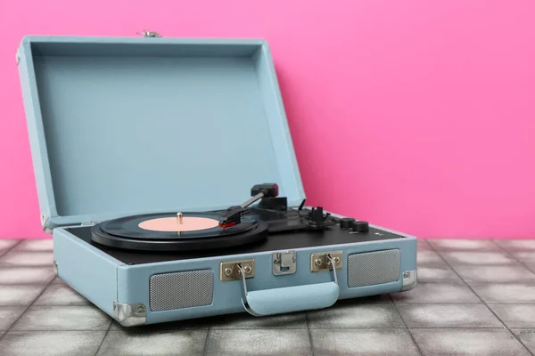ピンクの壁の近くのテーブルの上にビニールディスクを持つレコードプレーヤー — ストック写真