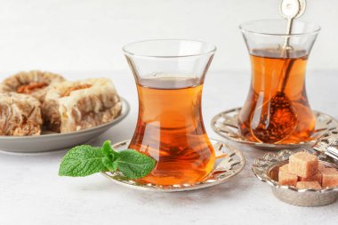 Beyaz arka planda bir bardak çay ve Türk lokumu