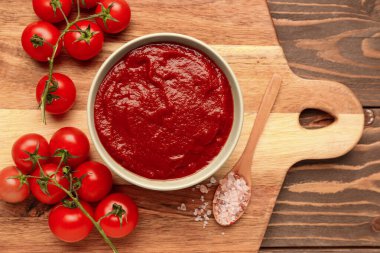 Lezzetli domates ezmesi ve ahşap arka planda taze sebzeli kase.