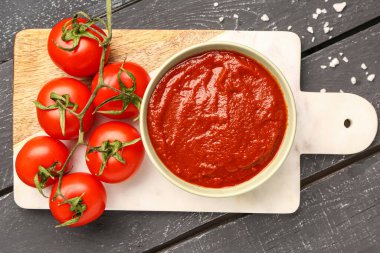 Lezzetli domates ezmesi ve koyu ahşap arka planda taze sebzeli kase.