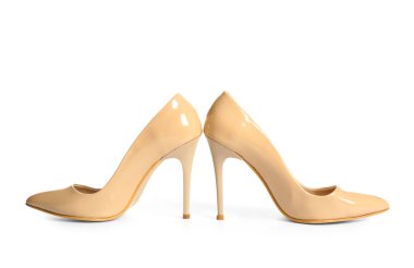 Beyaz arka planda bej renkli yüksek topuklu ayakkabılar.