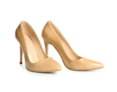 Beyaz arka planda bej renkli yüksek topuklu ayakkabılar.