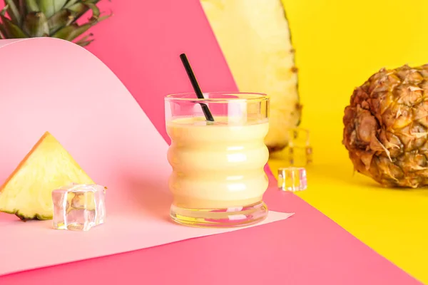 カラフルな背景においしいパイナップルスムージー わらと氷のキューブのガラス — ストック写真