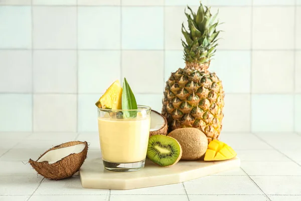 瓷桌上有一杯美味的菠萝冰沙 猕猴桃和椰子 — 图库照片