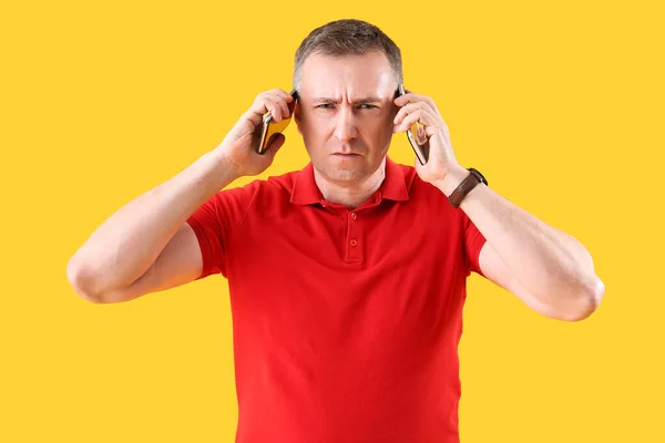 Dojrzałe Człowiek Rozmowy Przez Telefony Komórkowe Żółtym Tle — Zdjęcie stockowe