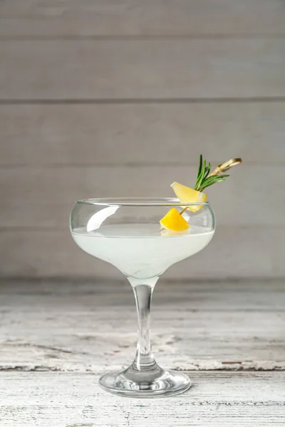 stock image Glass of martini with lemon on wooden table