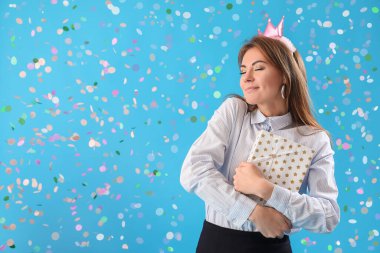 Güzel iş kadını mavi arka planda doğum gününü kutluyor.