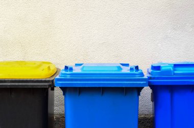 İnşaat duvarı yakınındaki çöp konteynırları, yakın çekim.