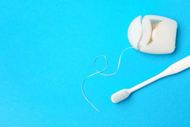Mavi arka planda diş ipi ve diş fırçası olan vaka