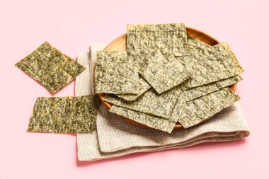 Pembe arka planda nori sayfaları olan bir tabak