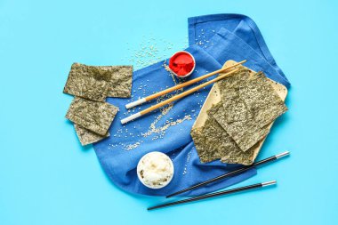 Renkli arkaplanda nori çarşafları, zencefil, pirinç ve çubuklarla kompozisyon